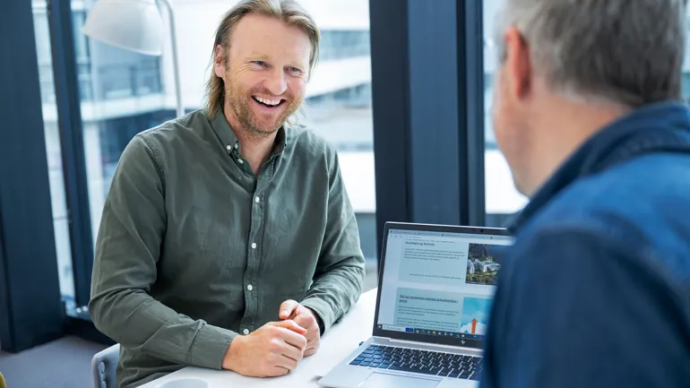 En mann som smiler til en annen mann